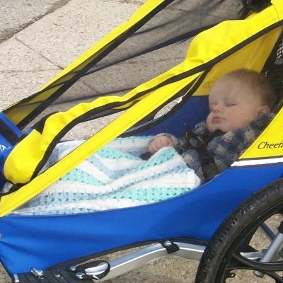 A baby sleeping in a sport stroller
