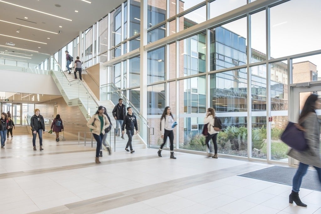 Busy campus foyer with students walking to class.