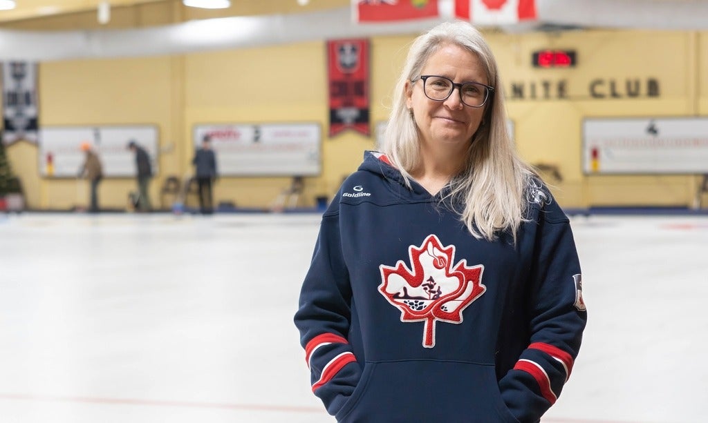 Heather Mair stands beside curling sheets at Waterloo's Granite Curling Club.