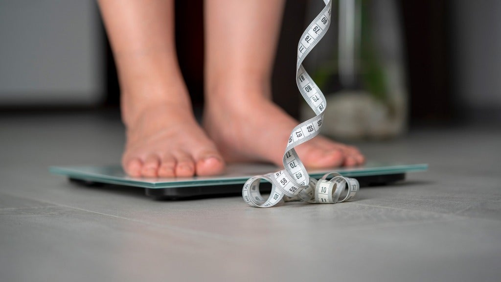 A person checks their weight and height.