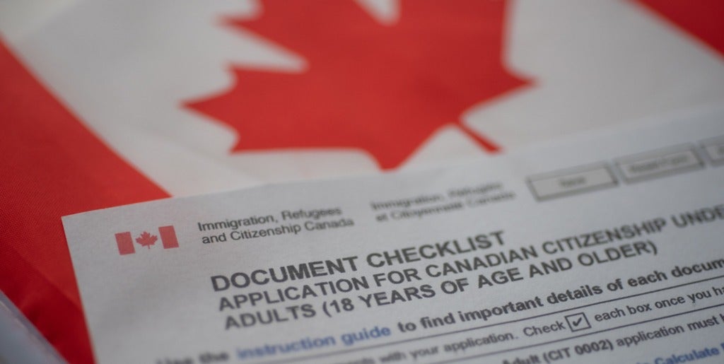 Citizenship form rests on Canadian flag.