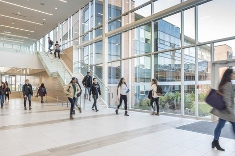 Busy campus foyer with students walking to class.