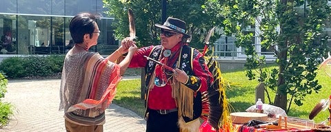 Dean Liu and Elder Henry holding up the Eagle Feather