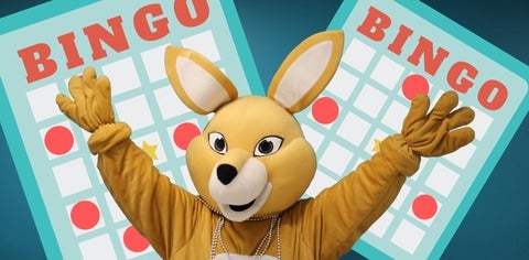 AHSSIE the mascot with arms up in front of bingo card.