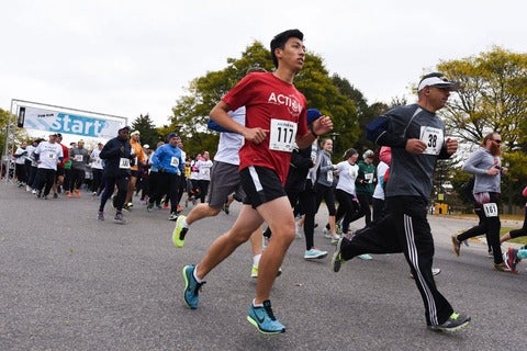 Runners break from the start line along campus ring road.