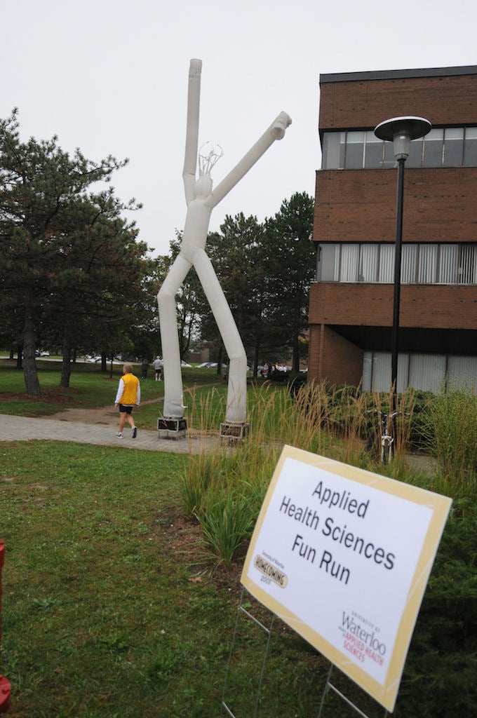 Inflatable floating balloon shaped as a person in front of Applied Health Sciences Building