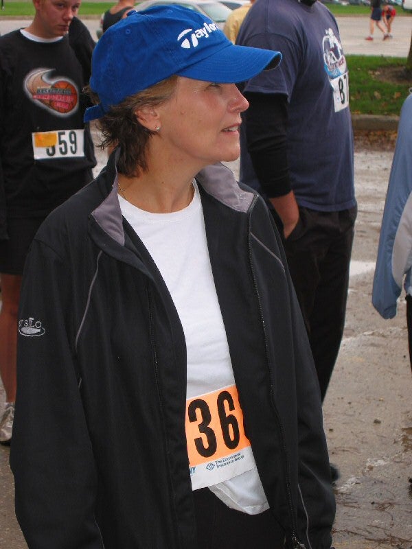A female participant with a blue cap paying attention to the speaker