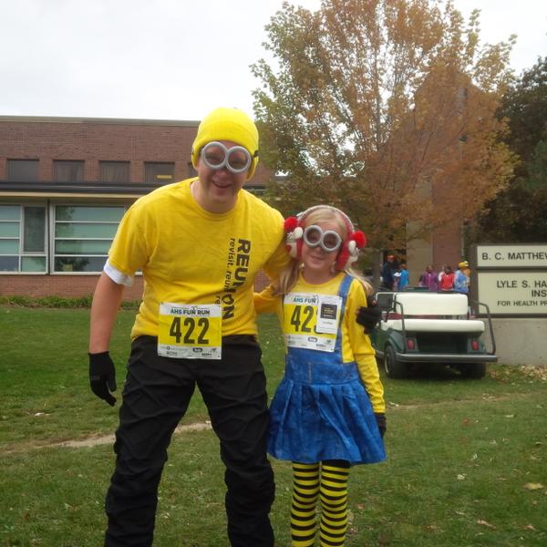Dad and daughter in minion costumes.