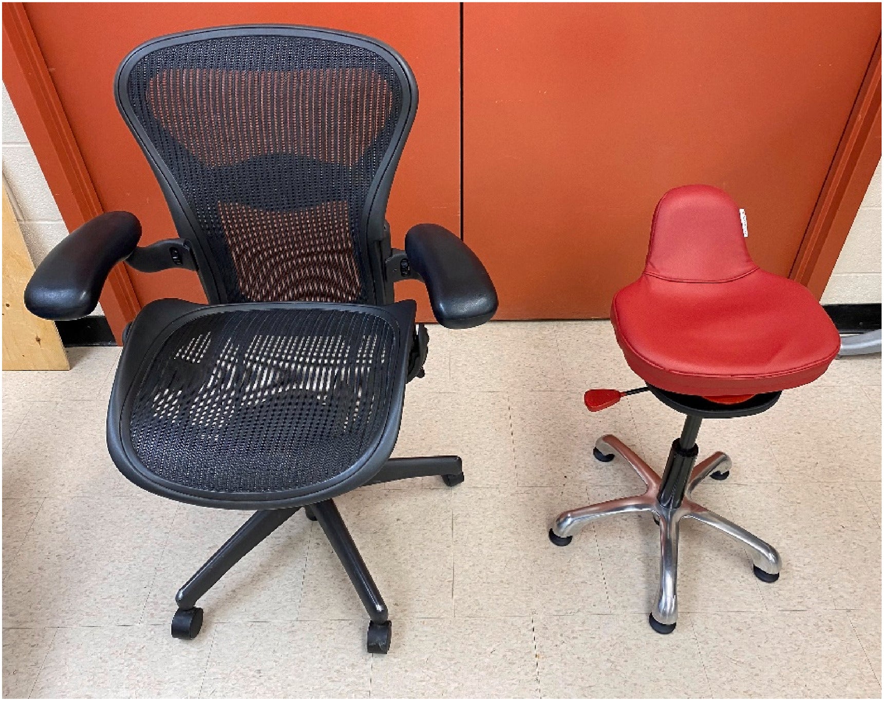A conventional office chair with arm rests and a back rest next to a backless dynamic chair.