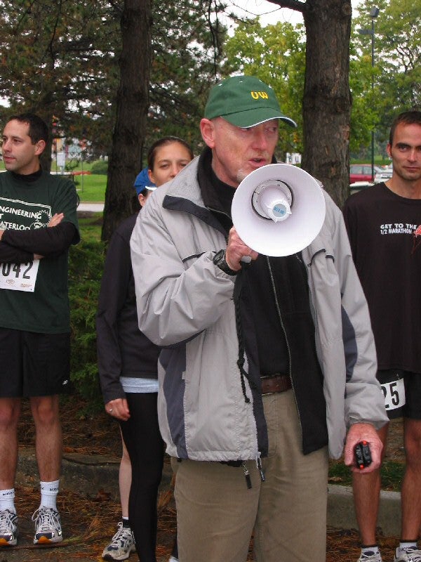 A man with a green cap talking through a megaphone
