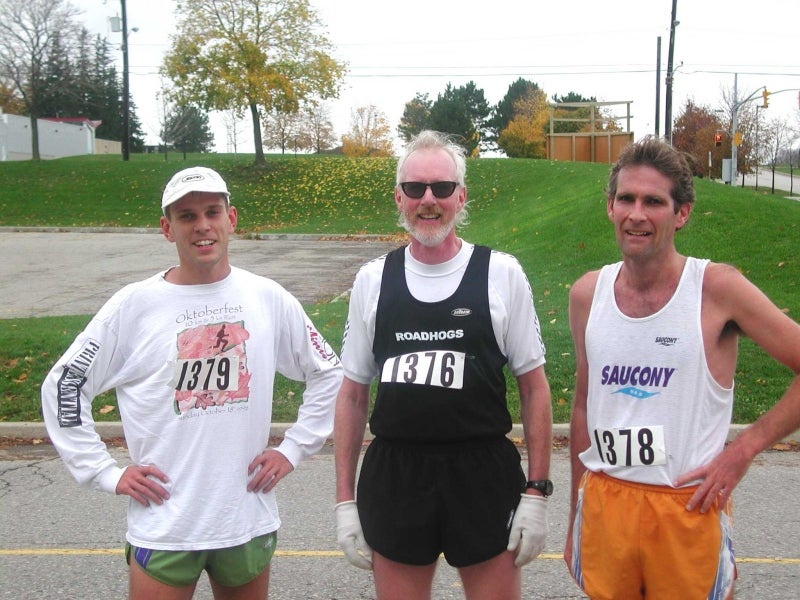 Three male runners taking a picture after the race