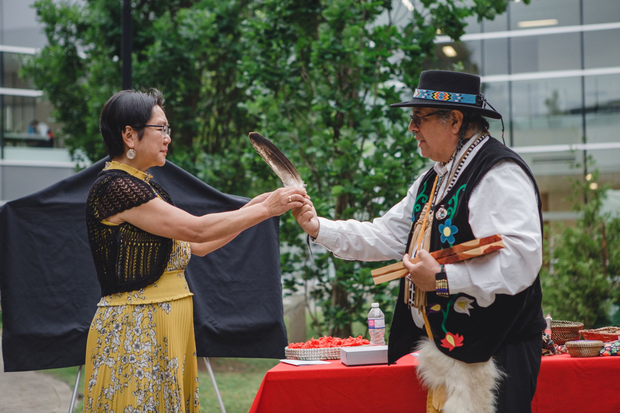 Lili Liu and Elder Myeengun pass a feather between the two of them at a previous recommitment ceremony.