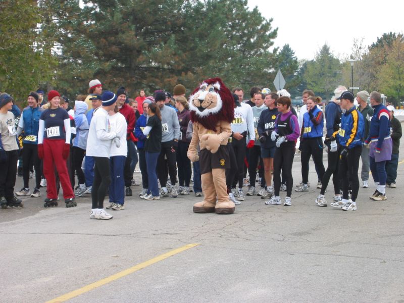 Runners and a lion mascot talking before the race begins