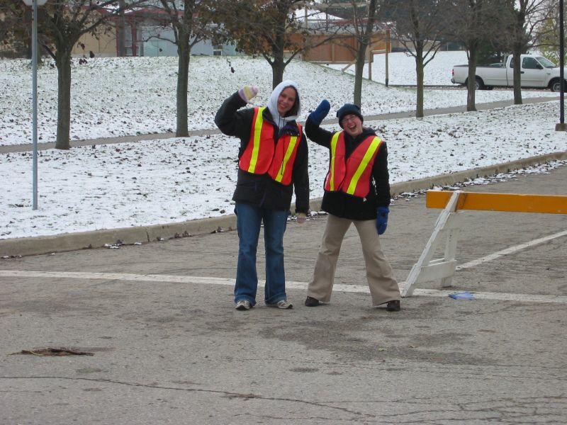Two staff members of Fun Run race waving hands towards the camera. 