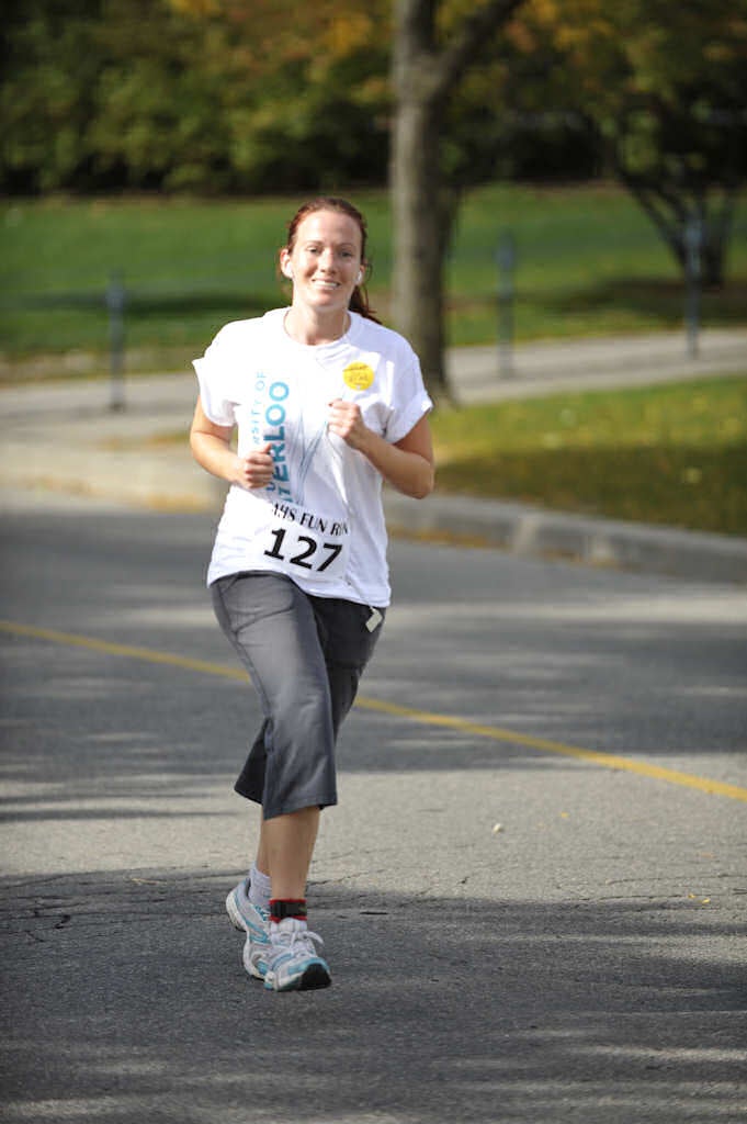 A female runner running while listening to music with her earphones