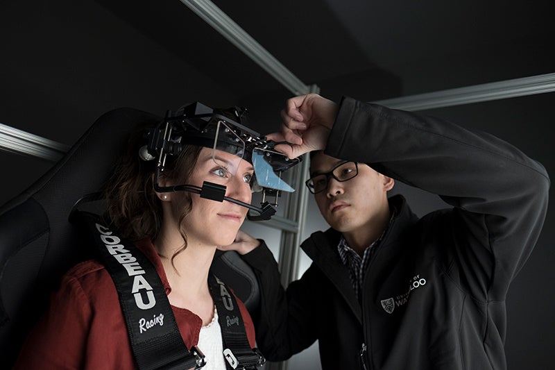Neuroscience grad student adjusts eye-tracking camera on research subject.