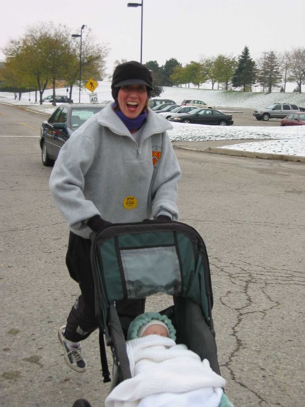 A woman running with her child in a baby stroller