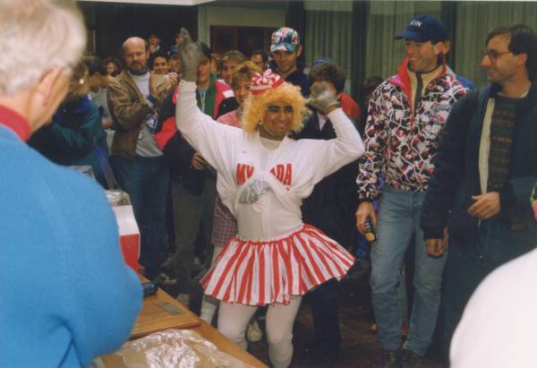 A man dressed up as a woman surrounded by people
