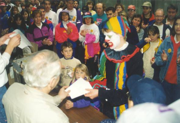 A man with a clown costume receiving a certificate during the after meeting.