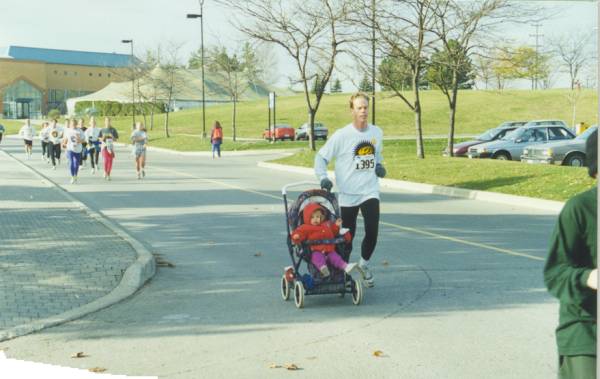 A man running the race with his baby in a baby stroller.