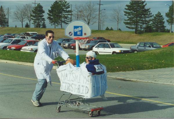 Two participants dressed as a doctor and a patient in a shopping cart.