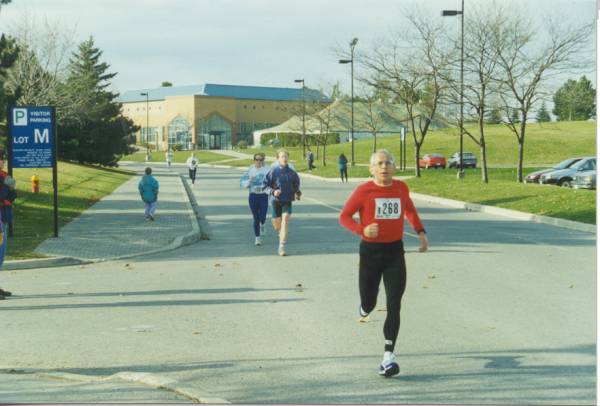 Runners passing by a parking lot. 