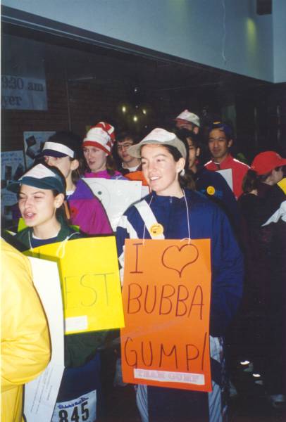 Two females with signs being focused saying "I LOVE BUBBA GUMP!" among people