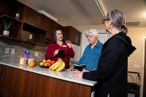 Heather Keller speaks with LTC residents about nutrition in a kitchen setting.