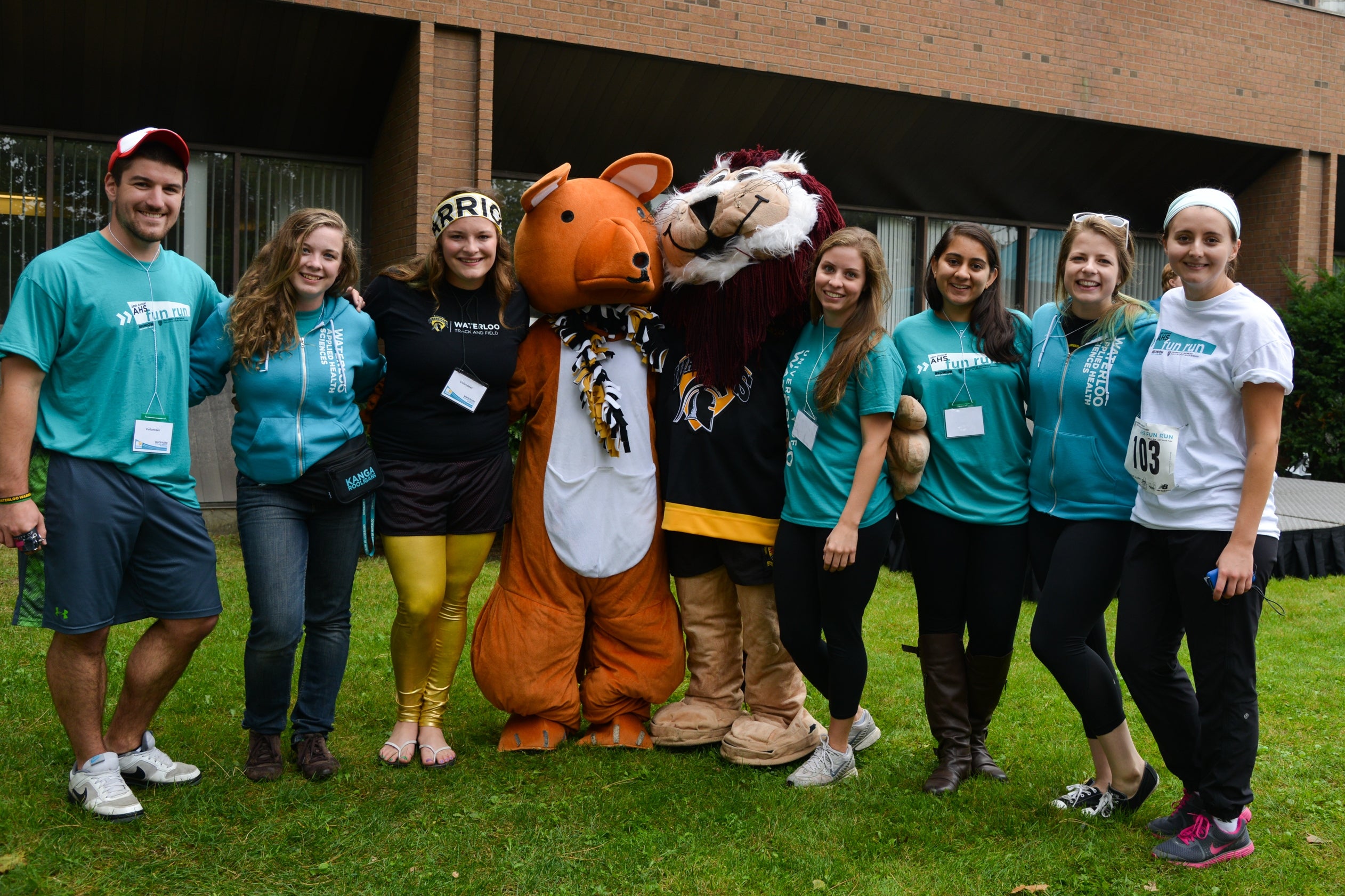 Seven students posing with two mascots.