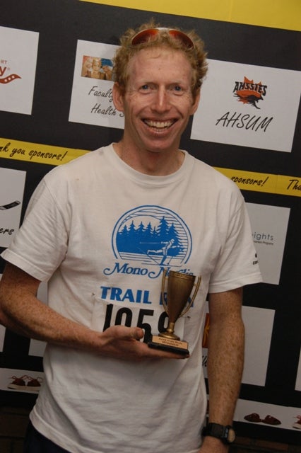 A man with a little trophy on his right hand