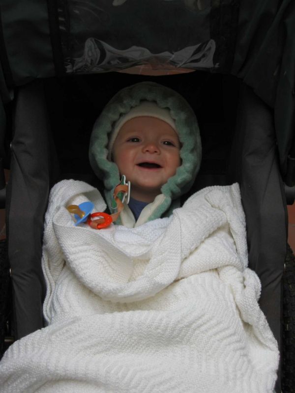 A baby wrapped in a towel smiling towards camera.