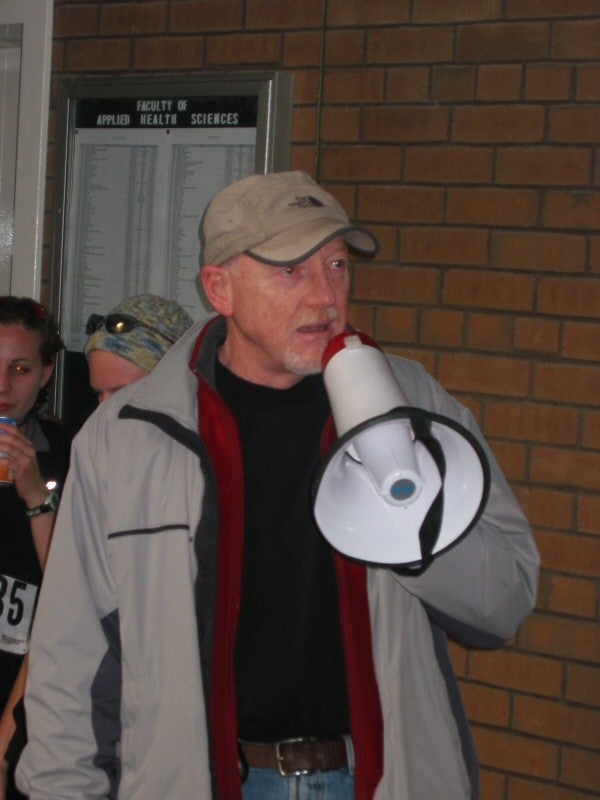 A man talking through a megaphone in a room after the race
