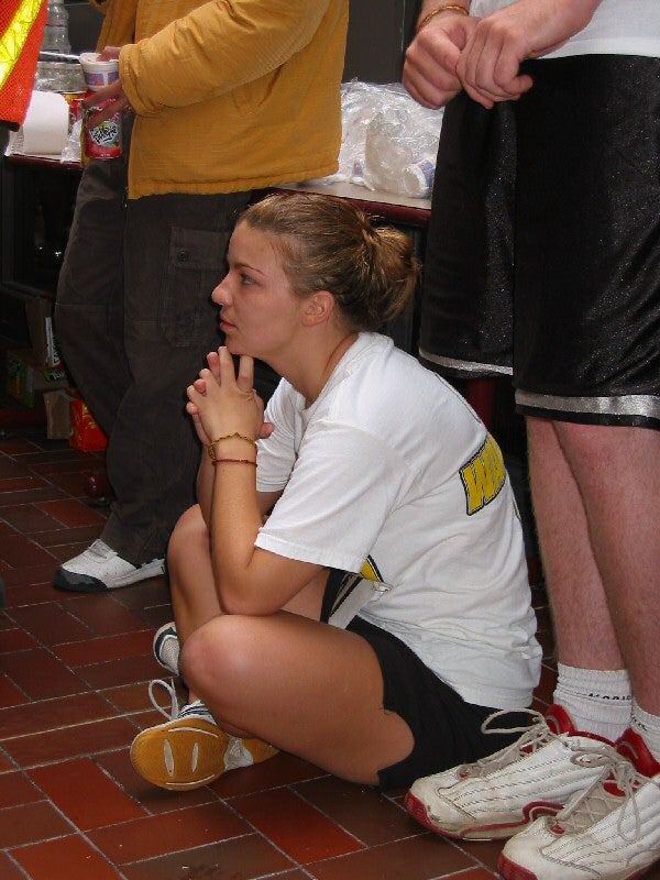 A female runner sitting on the floor during a meeting after the race