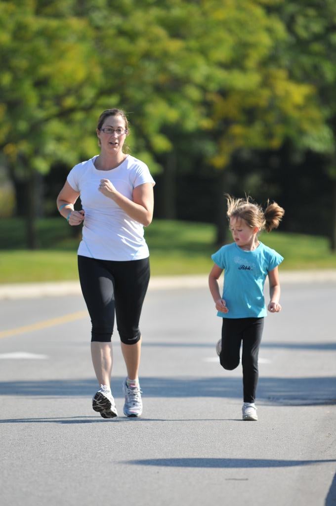 A woman running with a little girl right next to her