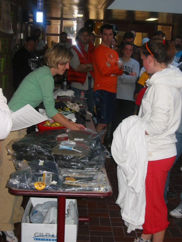A lady selling or giving out merchandise products