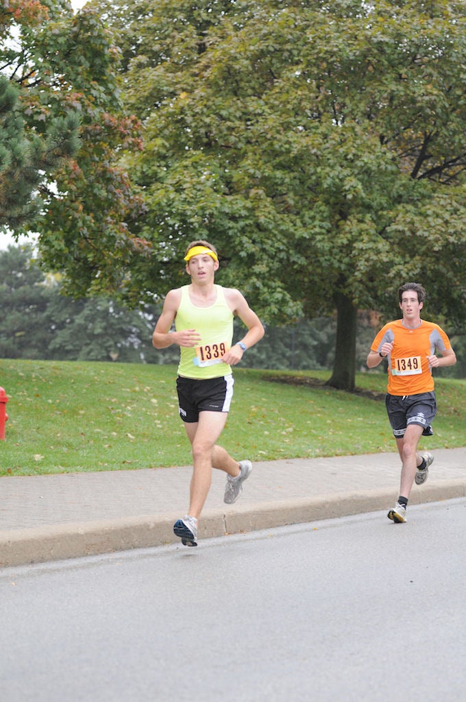 Two male participants running down the road
