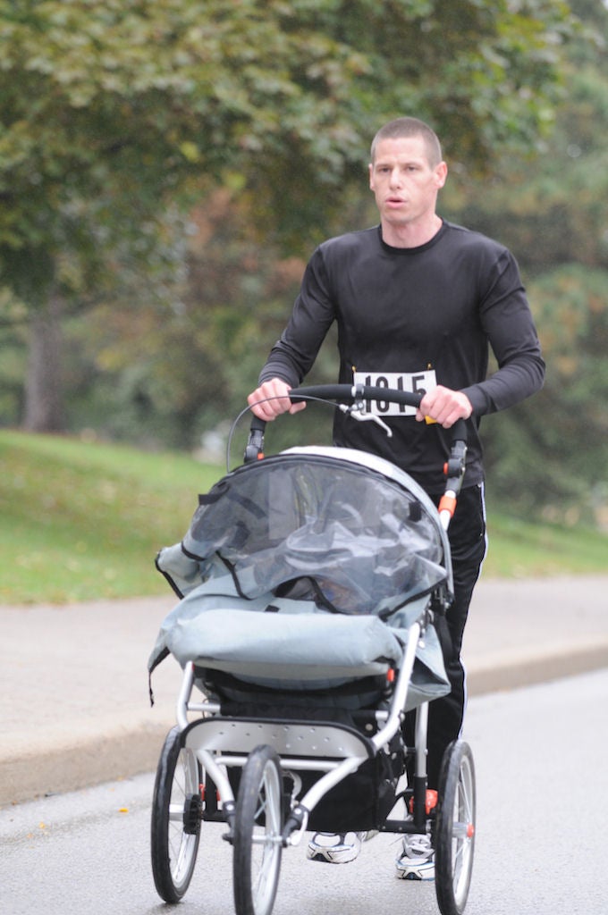 A man running with his baby in a baby stroller