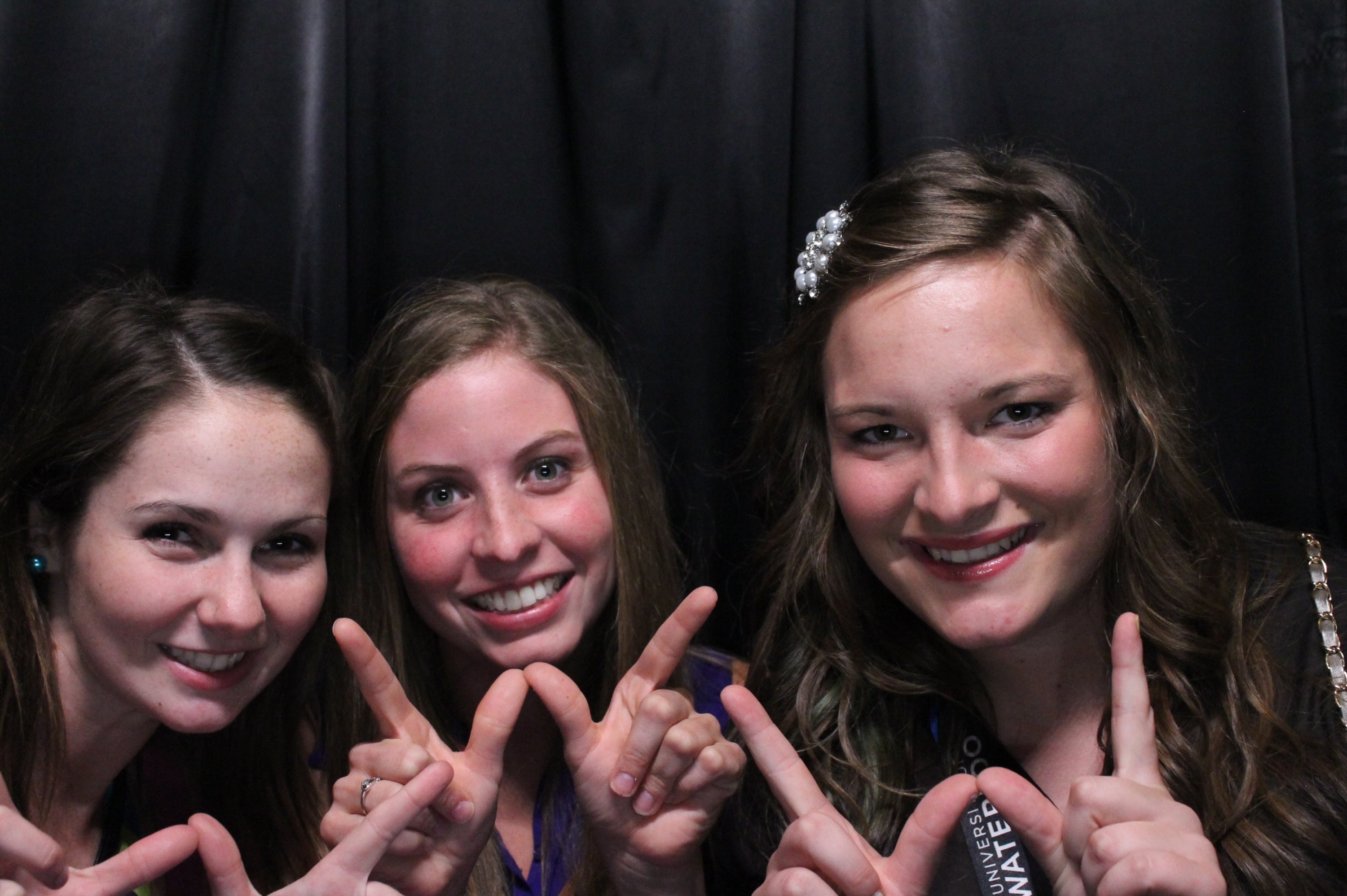 Three ladies posing for a photo while making a W with their hands.