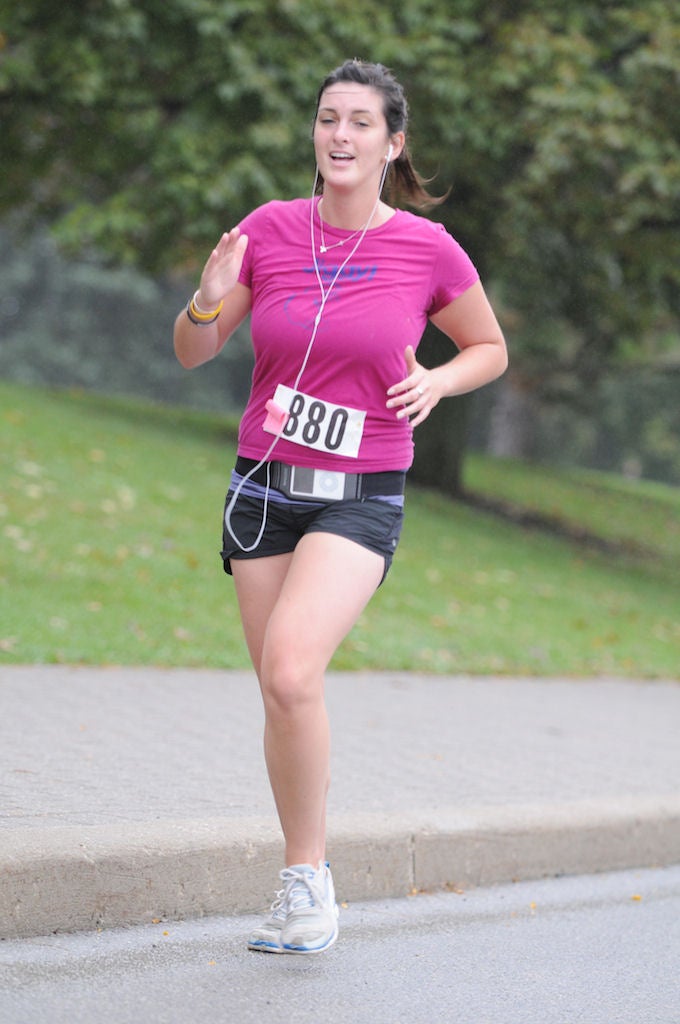 A female runner listening to music through earphones while running the race 