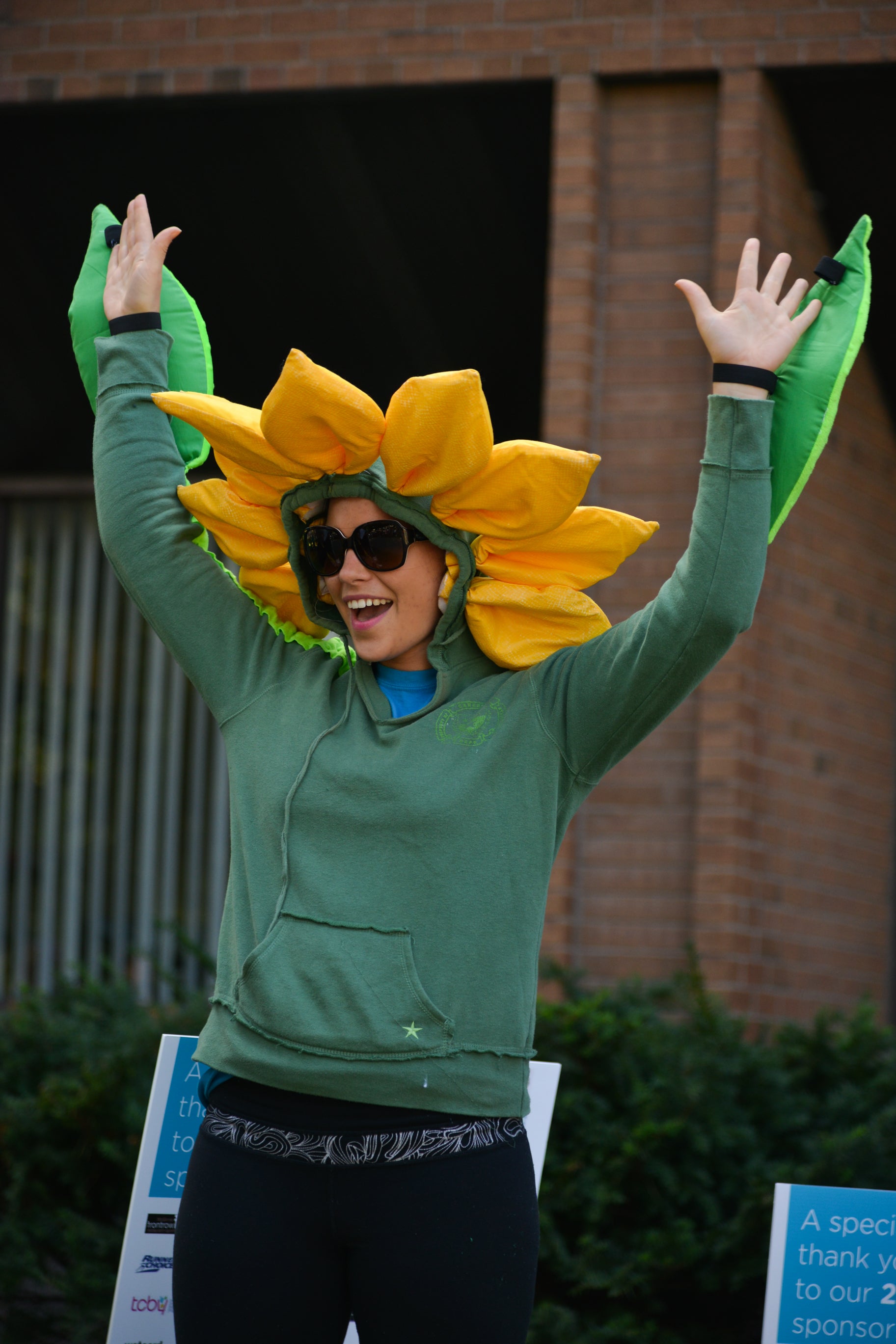 Lady smiling with her hands up dressed as a flower.