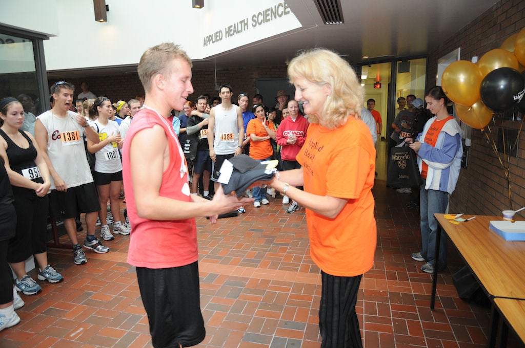 A man receiving a t-shirt from a female staff of Fun Run