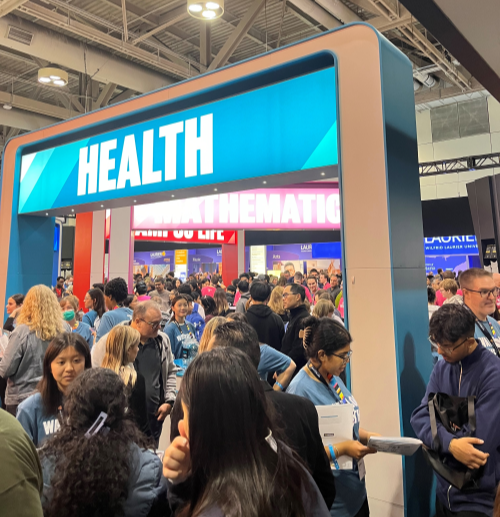 A large group of people crowd the Health booth at the Ontario Universities' Fair