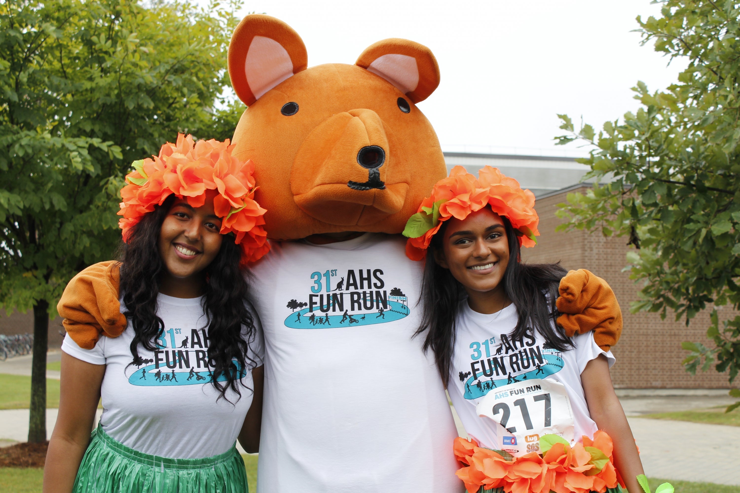 Two runners with AHSSIE the mascot