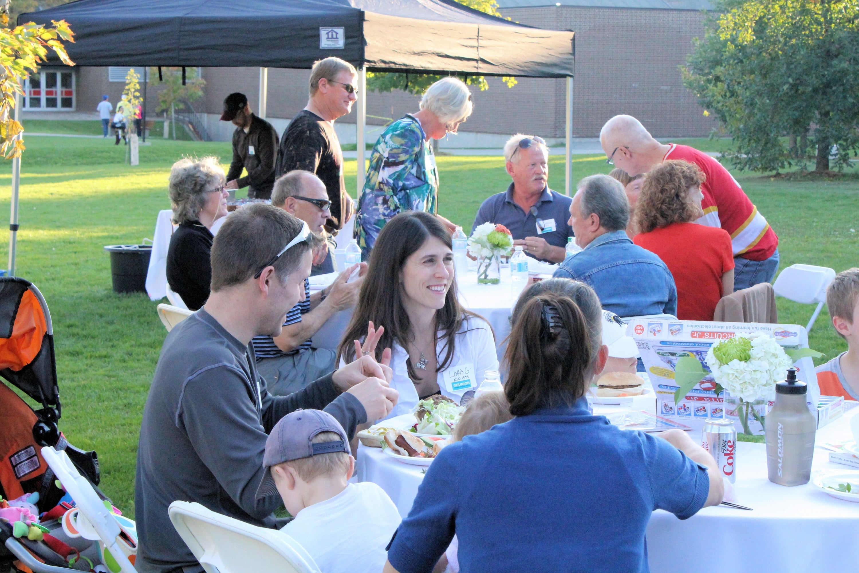 Families enjoying dinner at tables on the BMH Green.
