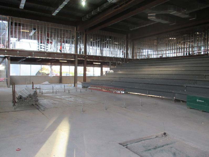 Lecture hall with concrete floor and base for tiered seating.