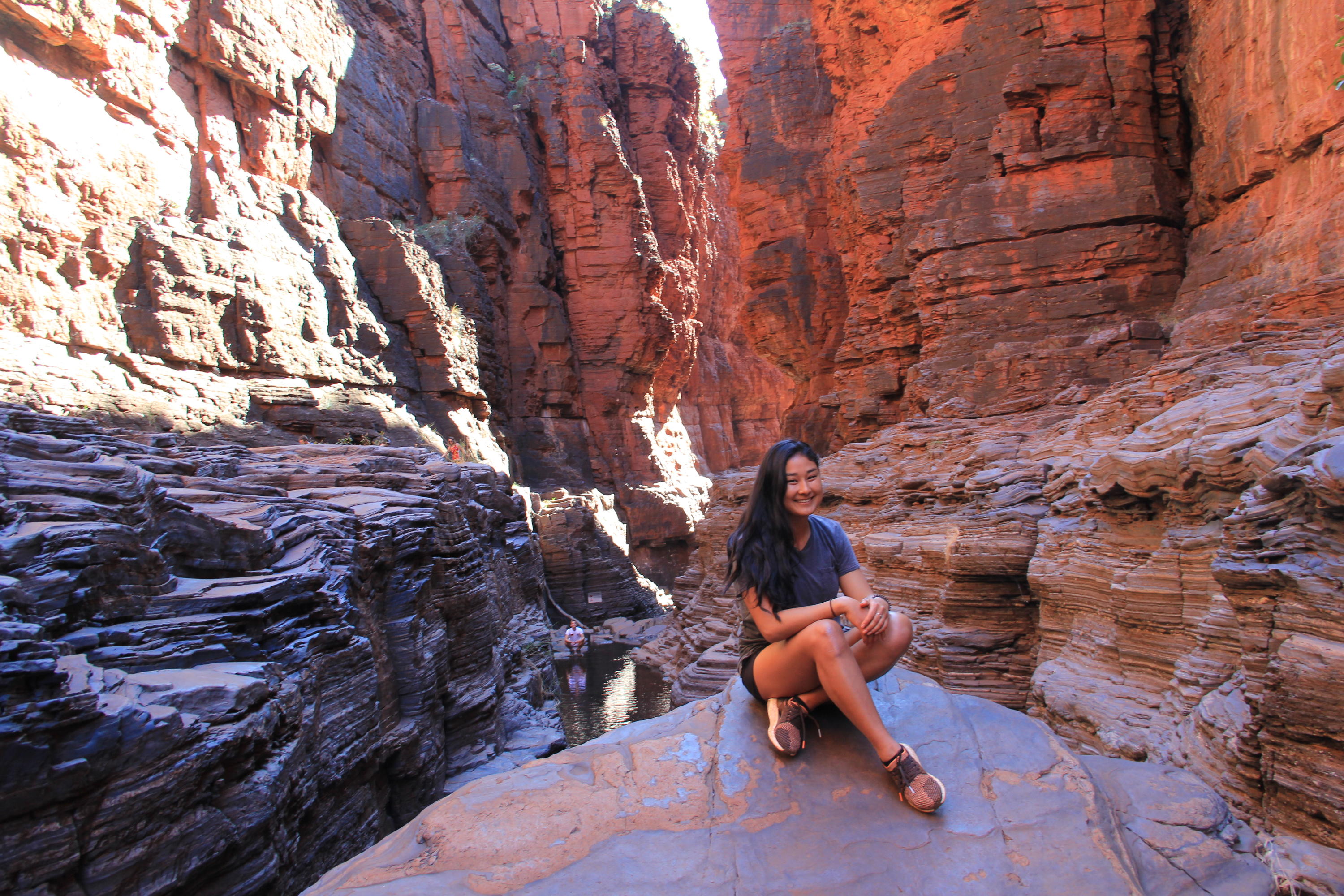 Cyanne seated at the base of a large gorge.