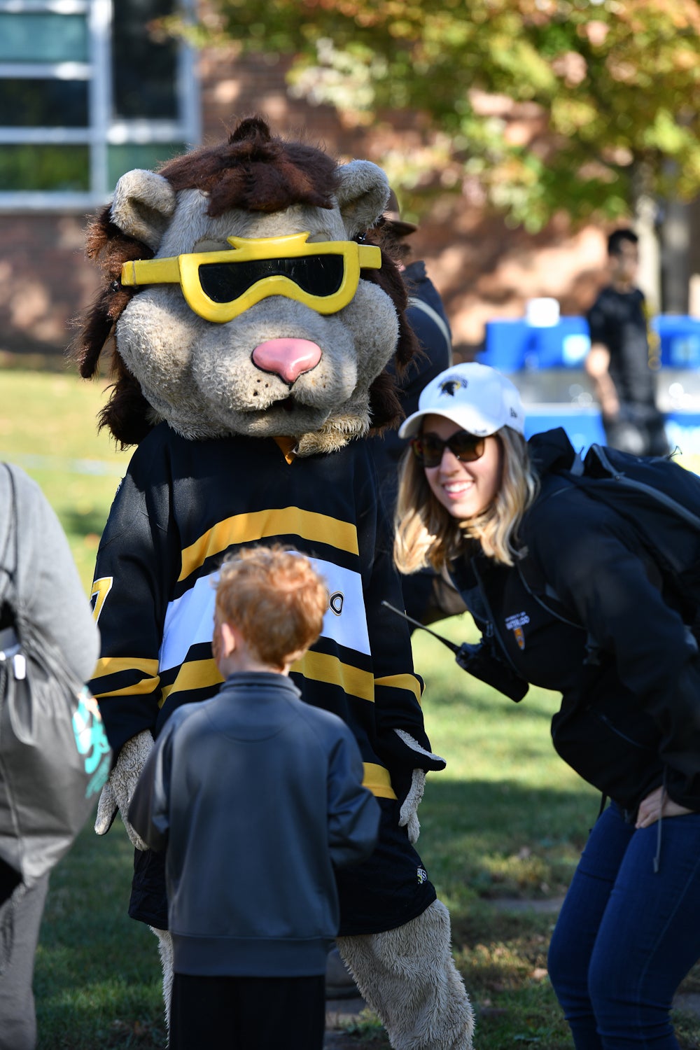 King Warrior, University of Waterloo mascot taking a photo with a child