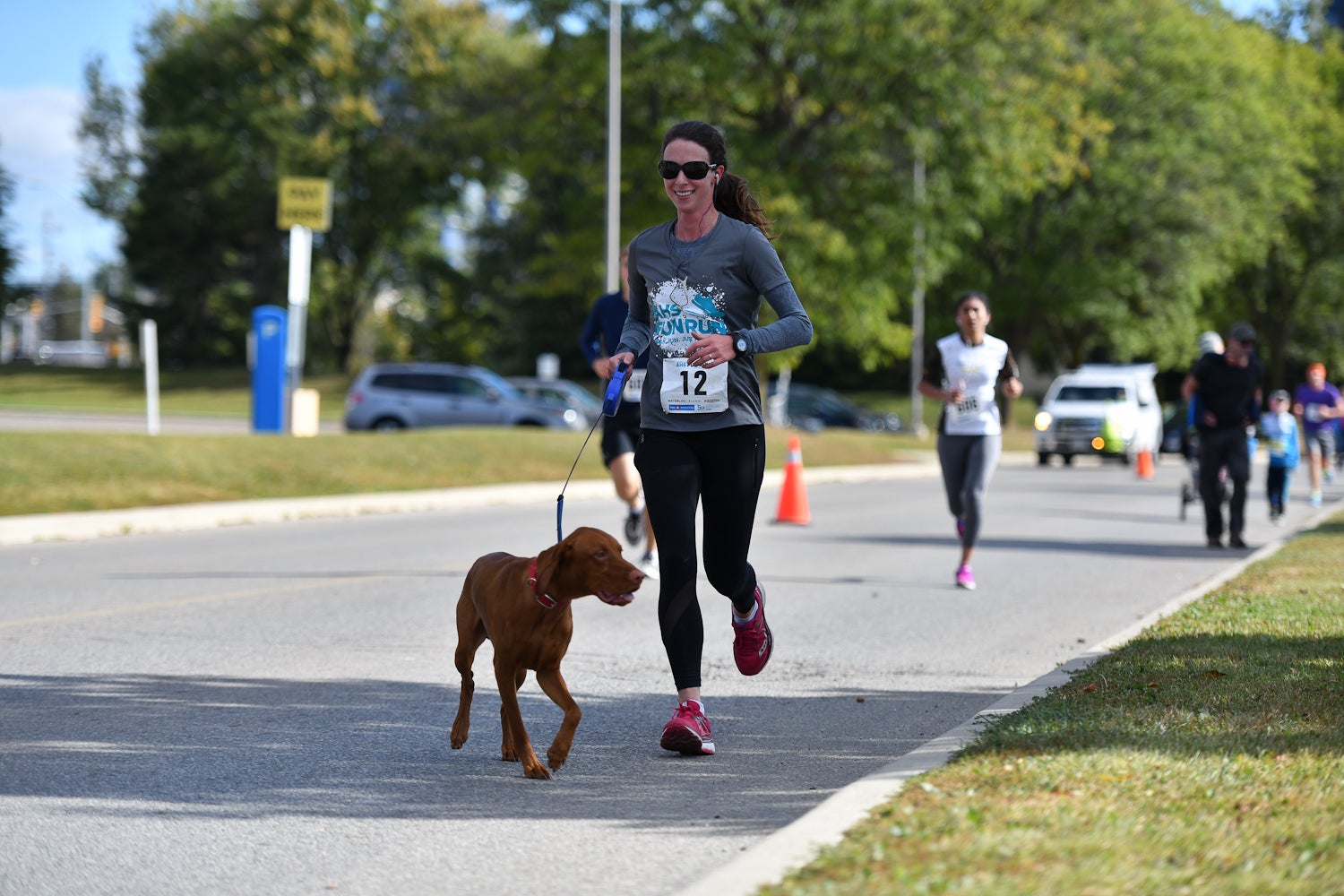 Female Fun Run participant running with a dog