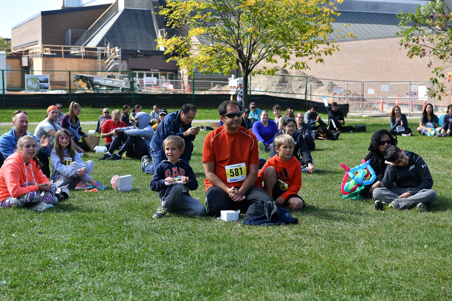 Fun Run participants sitting on the grass smiling