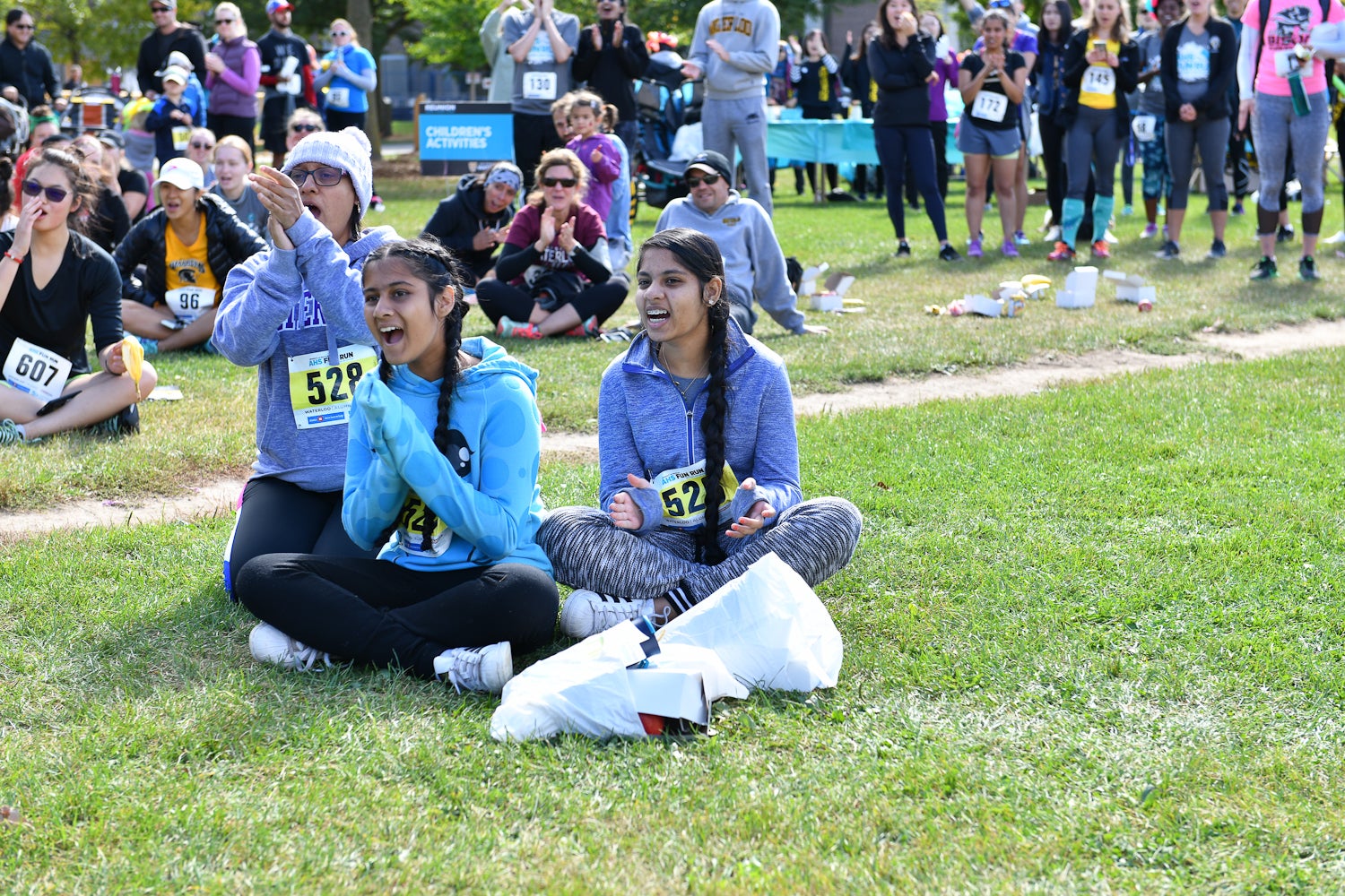 Fun Run participants sitting on the grass laughing
